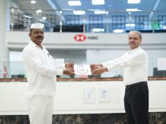 Hitendra Dave, Interim CEO, HSBC India handing over a tablet to Ulhas Muke for dabbawalas
